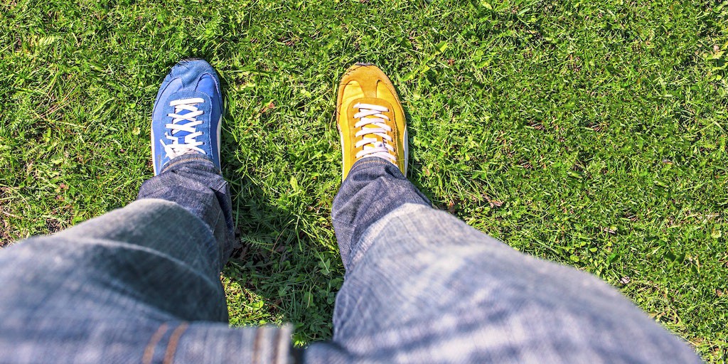 Photo of feet one blue shoe one yellow