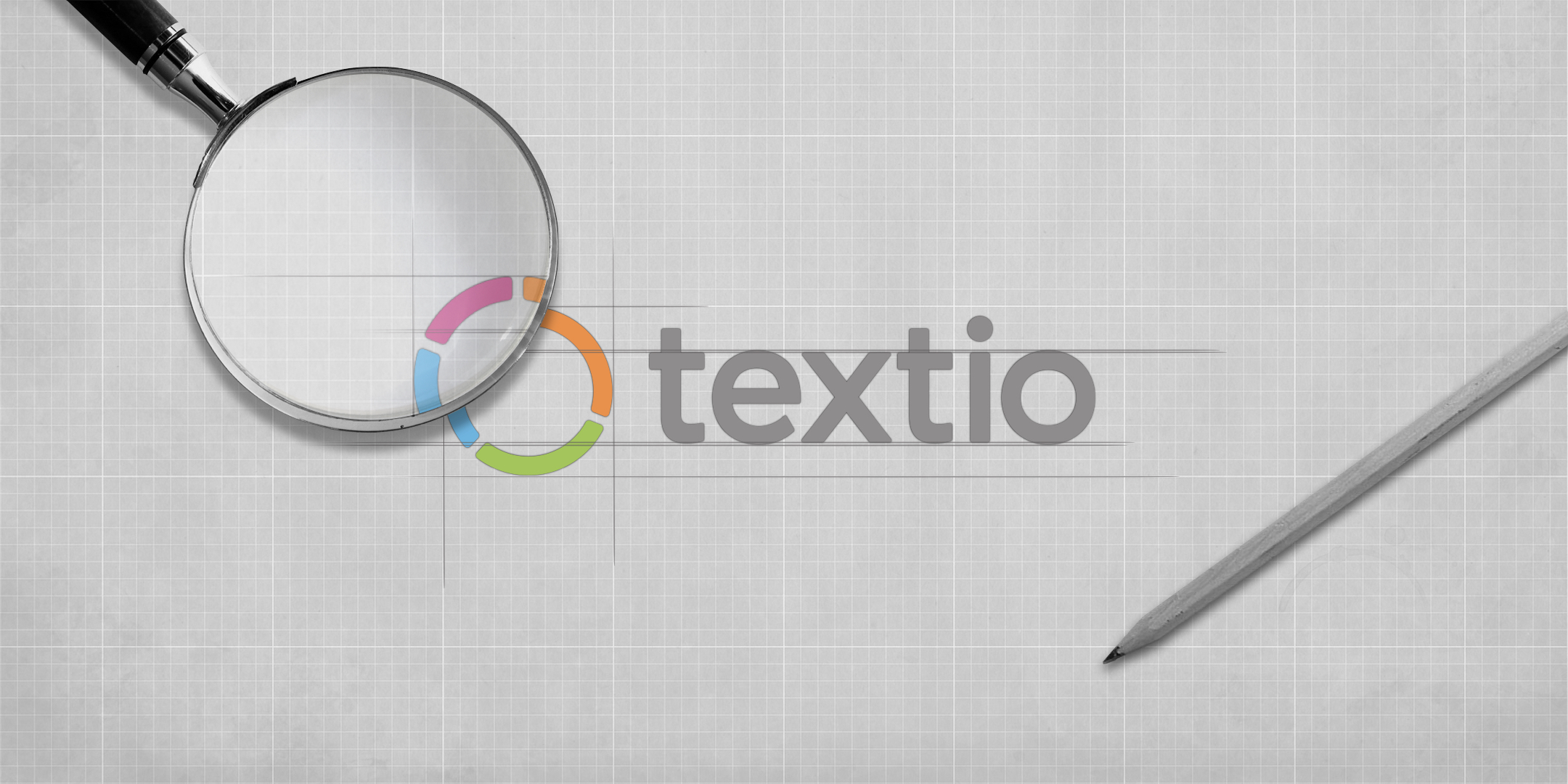 Textio logo on a sketchpad with a magnifying glass and pen visible