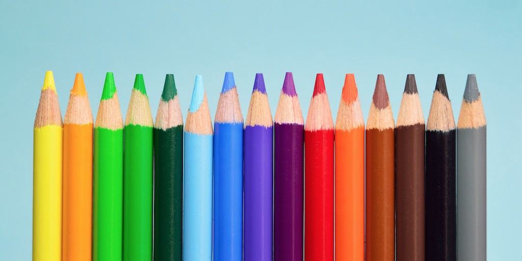 Line up of colored pencils creating a rainbow of colors