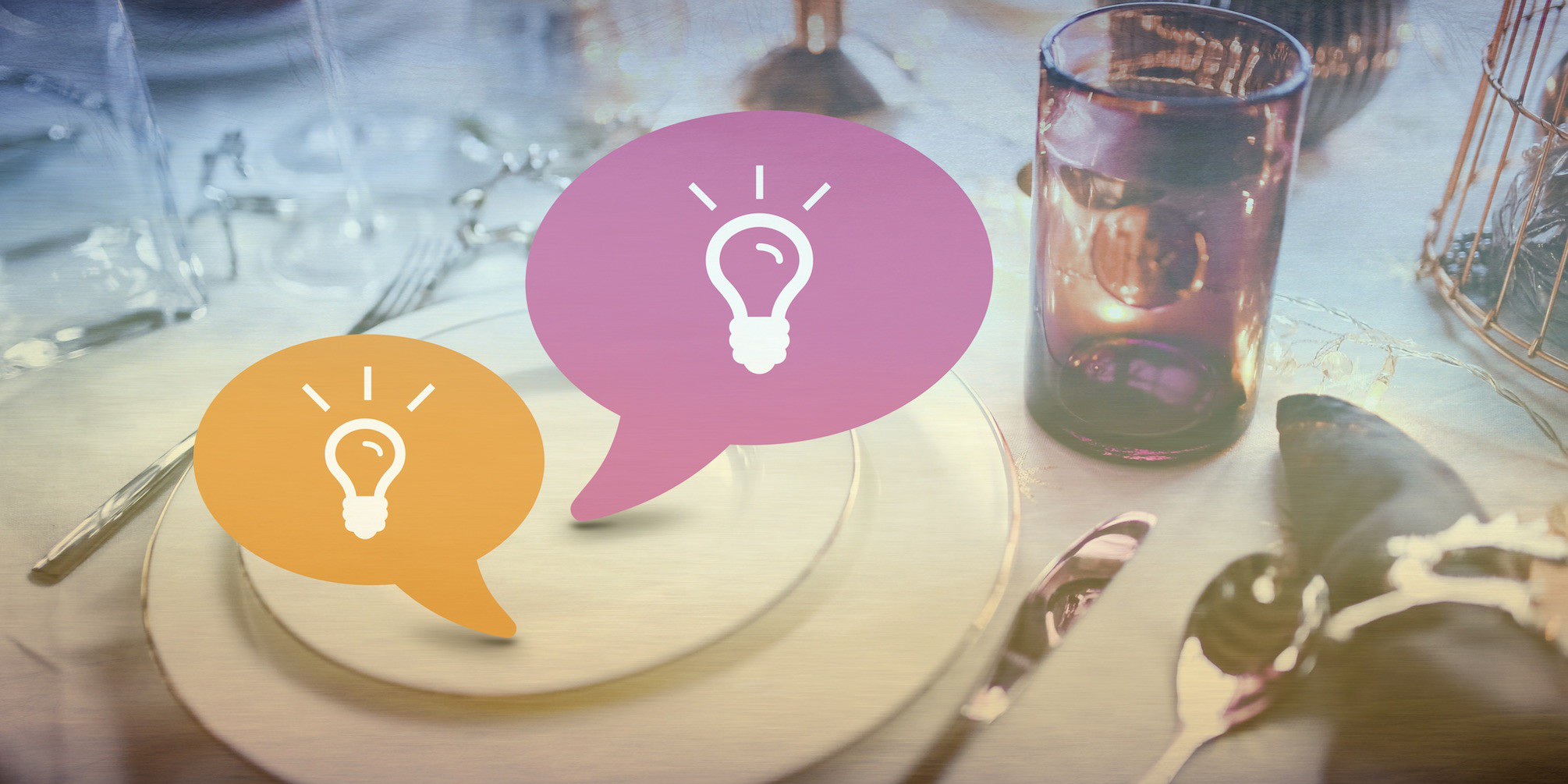 Two conversation bubbles on a place setting with light bulb icons in them